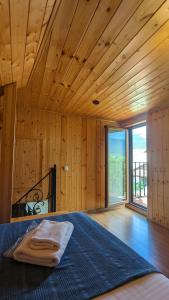 a bedroom with a bed in a room with wooden walls at Levanto in Mtskheta