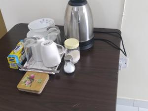 Daily stay Royal flat في دبي: طاولة مع آلة صنع القهوة وأكواب عليها