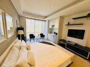 a bedroom with a large bed and a flat screen tv at Love Luxe @ Sandton skye in Johannesburg