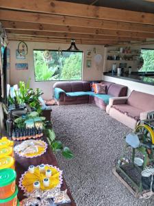 uma sala de estar com um sofá e uma mesa em EcoPousada - Sitio Aborigene em São Lourenço do Oeste