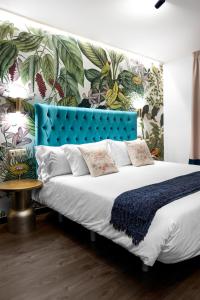 a bed with a blue headboard in a room at Hotel Los Girasoles in Granada