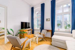 ein Wohnzimmer mit einem Sofa und einem TV in der Unterkunft Plac Grunwaldzki Cosy Apartment in Breslau