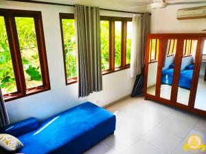 Zimmer mit blauem Sofa in einem Zimmer mit Fenstern in der Unterkunft 3Bedroom Villa Kepiting Sanur in Sanur