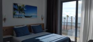 a bedroom with a bed and a view of the beach at Anxhelos Hotel in Himare