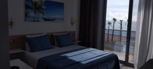 a bedroom with a bed with a view of the ocean at Anxhelos Hotel in Himare