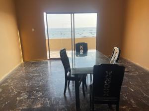 a dining room with a table and chairs and the ocean at Rayyan Beach House in Karachi
