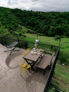 una terrazza in legno con tavolo e sedie. di Dream Domes Glamping a Gabala