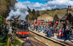 a crowd of people waiting to board a train at a train station at Prince St Cottage - Haworth - Sleeps 4 in Haworth