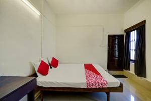 Thodupuzha的住宿－Ceasar Palace Annex，一间卧室配有一张带红色枕头的床和一扇窗户