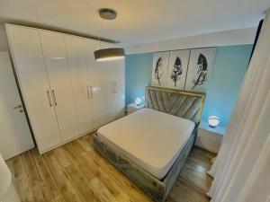 1 dormitorio con 1 cama y armarios blancos en Central Apartment Blloku, en Tirana