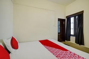 1 dormitorio con 1 cama con manta roja en Ceasar Palace Annex, en Thodupuzha