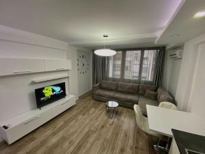 sala de estar con sofá y TV en Central Apartment Blloku, en Tirana