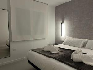a bedroom with a large bed with towels on it at La vía in Santa Eulalia