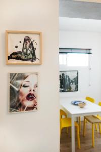 a dining room with pictures on the wall and a table at Casa Miguel - Apartamento 4 in Sanlúcar de Barrameda