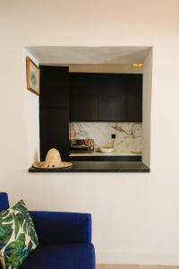 cocina con armarios negros y sofá azul en Casa Miguel - Apartamento 4, en Sanlúcar de Barrameda