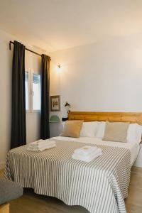 1 dormitorio con 1 cama grande y 2 toallas. en Casa Miguel - Apartamento 4, en Sanlúcar de Barrameda