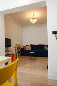 sala de estar con sofá azul y TV en Casa Miguel - Apartamento 4, en Sanlúcar de Barrameda