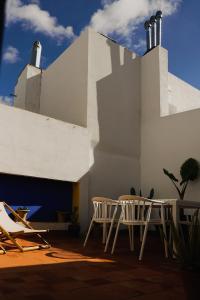 a patio with chairs and a table and a building at Casa Miguel - Apartamento 4 in Sanlúcar de Barrameda