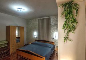 a bedroom with a bed with a plant on the wall at PARADINOVIC house with apartments in Zambratija