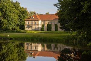 an old house with its reflection in the water at Palac Czerniejewo in Czerniejewo