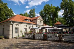 a building with flowers and umbrellas in front of it at Palac Czerniejewo in Czerniejewo