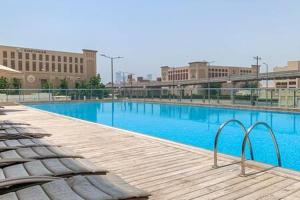a large blue swimming pool with buildings in the background at Frank Porter - Palm Views West in Dubai