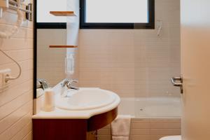 a bathroom with a sink and a tub at Pierre & Vacances La Merceria in El Tarter