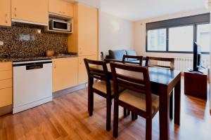 a kitchen and dining room with a table and chairs at Pierre & Vacances La Merceria in El Tarter