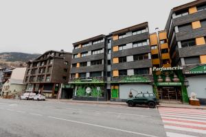 uma rua com edifícios e um carro estacionado na rua em Pierre & Vacances La Merceria em El Tarter