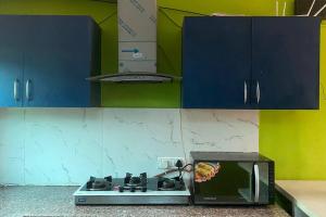 a kitchen with a stove and a microwave at Moksha Farm, 3BHK Luxury Farm Stay, 7000 sq ft in Noida