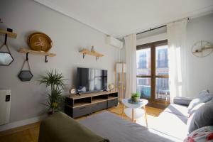 uma sala de estar com um sofá e uma televisão em LG Apartamento exclusivo de lujo em Madri