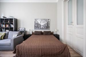 a bedroom with a large bed and a couch at BpR Castle Hill Apartment with Garden in Budapest