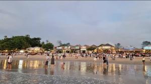 a group of people standing on a beach at Spacious Room Jimbaran in Jimbaran