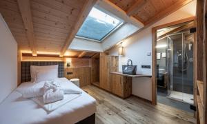 ein Schlafzimmer mit einem großen Bett und einer Dusche in der Unterkunft Hotel Schmung in Alpe di Siusi