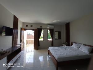 a bedroom with a bed and a large window at Spacious Room Jimbaran in Jimbaran