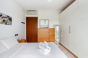 een slaapkamer met een wit bed en handdoeken bij Accogliente Bilocale con Giardino e Parcheggio in Monza