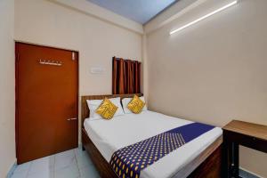 a small bedroom with a bed and a door at SPOT ON RKH Inn in Chennai