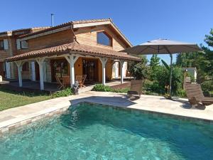 a house with a swimming pool and an umbrella at Ecolodge Bellevue ALBI in Albi