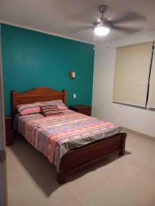 a bedroom with a bed and a ceiling fan at Hermoso departamento, excelente vista al mar in Tonsupa