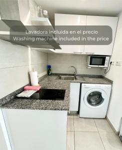 a kitchen with a washing machine and a sink at Chocolate Brownie Piscina, Terraza, Planta baja, parking y WIFI in Corralejo