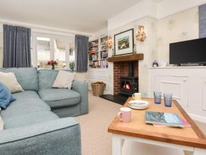 a living room with a blue couch and a fireplace at 3 Bed in Cerne Abbas 74803 in Cerne Abbas