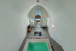 een woonkamer met een zwembad in een huis bij Luxurious Santorini Masionette Villa - 1 Bedroom - Astounding Caldera Sea Views and Private Outdoor Hot Tub - Fira in Fira