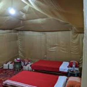 a room with two beds in a tent at Ibra desert Camp in Merzouga