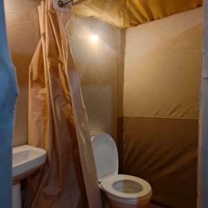 a small bathroom with a toilet and a sink at Ibra desert Camp in Merzouga