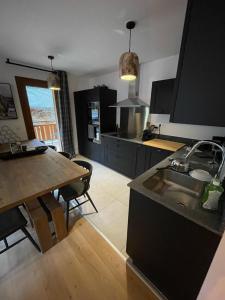 a kitchen with a sink and a table and a table and chairs at Alpine Creek Chalet Luxury Ski-in in Morzine