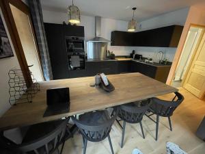 a kitchen with a wooden table and some chairs at Alpine Creek Chalet Luxury Ski-in in Morzine