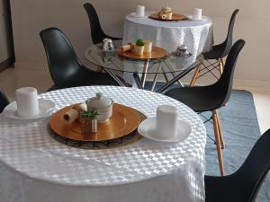 SERENE Guest House في ميدراند: طاولة عليها صحن طعام مع كراسي