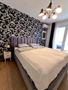 ein Schlafzimmer mit einem großen Bett mit einer schwarz-weißen Wand in der Unterkunft Luxurious studio apartment close to the beach and airport in Porto Rafti