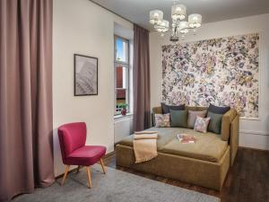 a living room with a couch and a red chair at 4 Arts Apartments by Adrez in Prague