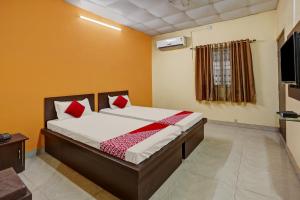 a bedroom with a bed with red pillows at OYO Flagship Sanskar Garden in Rānchī